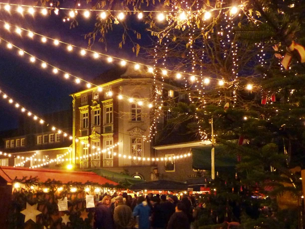 Nächtlicher Weihnachtsmarkt in Mettmann mit festlicher Beleuchtung und einem dekorierten Tannenbaum.
