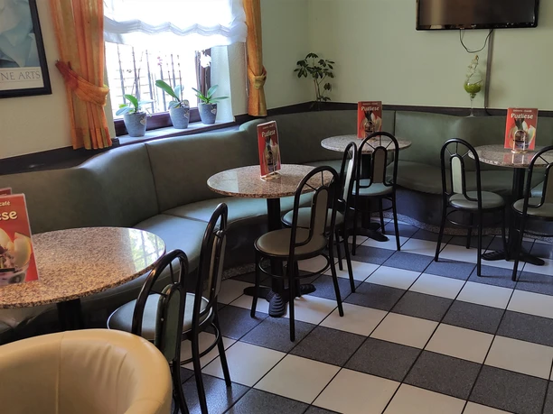 Der Innenbereich des Eiscafés Pugliese besticht durch eine gemütliche Sitzgruppe mit runden Tischen.