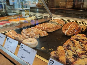 Auslage Eine gläserne Vitrine zeigt eine Auswahl an verschiedenen, frisch gebackenen Backwaren.