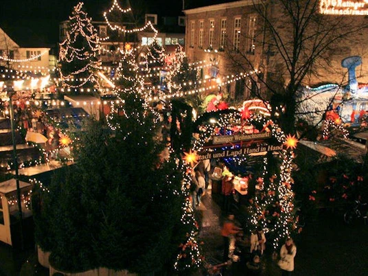 Weihnachtsmarkt-in-Ratingen-Vogelperspektive.jpg Weihnachtsmarkt in Ratingen bei Nacht aus der Vogelperspektive mit leuchtenden Lichterketten und Buden.