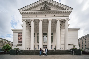 Theater Duisburg <p>Frontansicht eines großen, klassischen Gebäudes mit Säulen und einer weiten Treppe davor.</p>