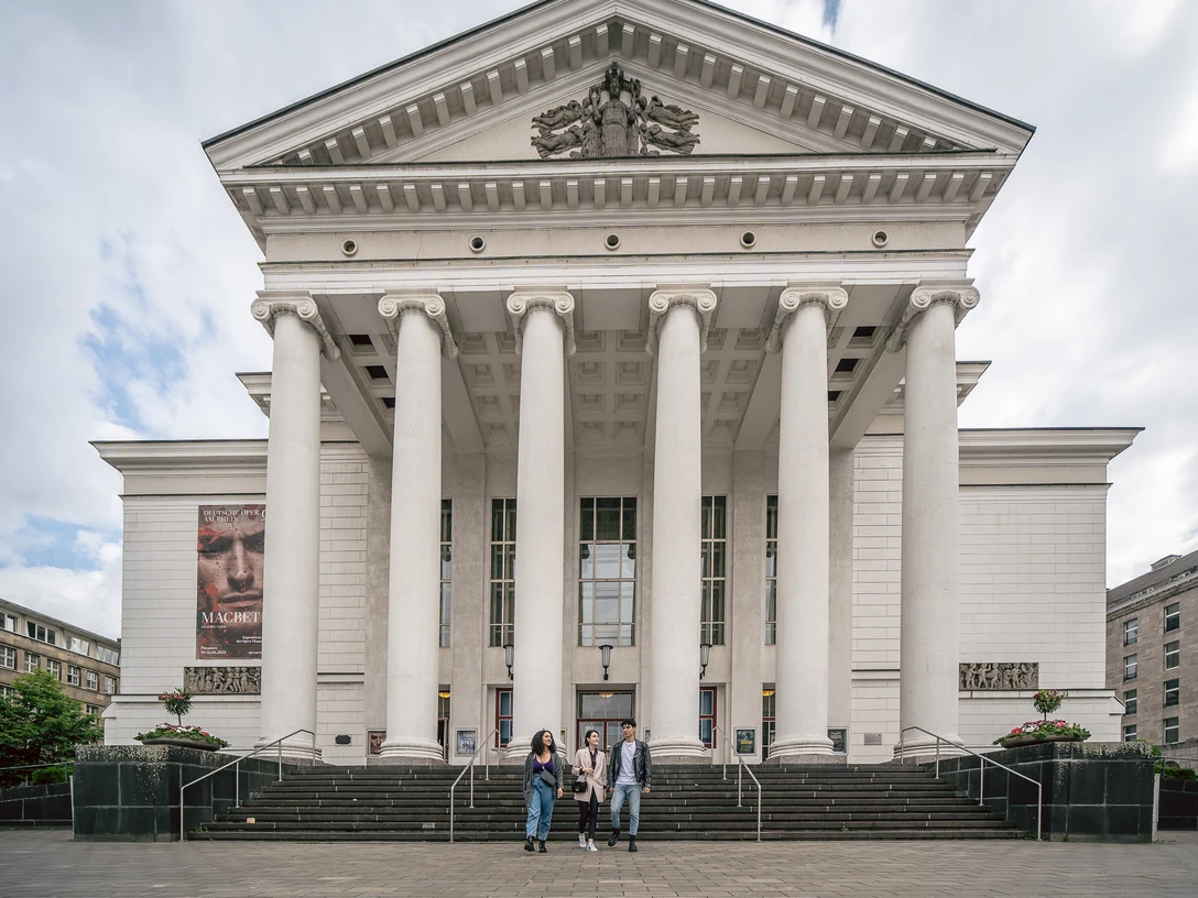 Theater Duisburg <p>Frontansicht eines großen, klassischen Gebäudes mit Säulen und einer weiten Treppe davor.</p>