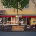 Knut's, Witten <p>Fahrräder und Tische vor einem Café mit rotem Markisendach und gelber Fassade.</p>