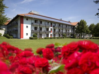 RoseKlinik Aussenaufnahme© MEDICLIN Rose Klinik.jpg Das Gebäude mit roten Dachziegeln und Loggias steht vor einem Rasen, eingerahmt von roten Rosen.