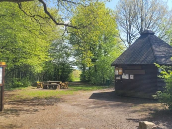 Wiehenturm Pausenplatz Runder Holzturm mit Rastplatz, umgeben von Bäumen, Picknicktisch und Infotafel am Waldrand.
