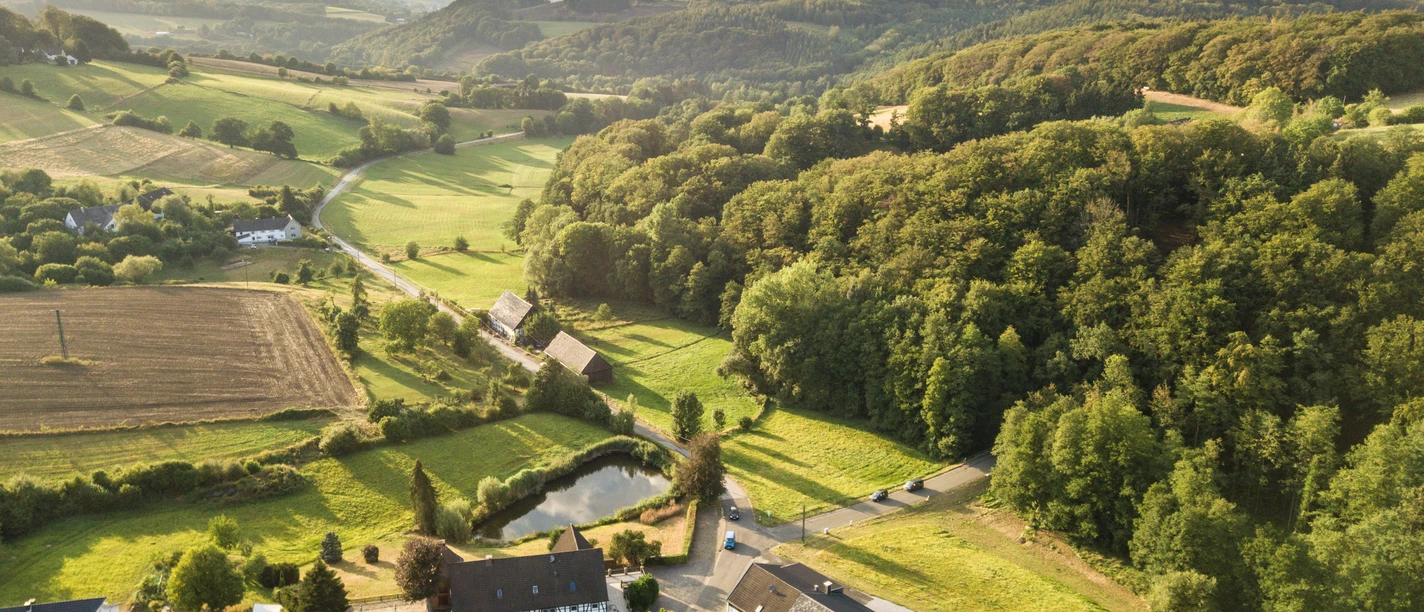 Windrather Tal bei Velbert Luftaufnahme des Windrather Tals bei Velbert mit Feldern, Wäldern und vereinzelten Gebäuden im Abendlicht.