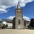 Alte Kirche in Velbert Alte Kirche in Velbert mit steilem Turm und Uhr, umgeben von modernen Gebäuden und blauem Himmel.