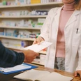 Customer handing over a prescription to the chemist Customer handing over a prescription to the chemist