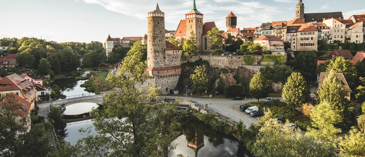 Bautzen_Alte_Wasserkunst_Foto_20_Phillip_Herfort.jpg Blick auf die historische Alte Wasserkunst in Bautzen mit umgebender Altstadt und grünem Fluss.