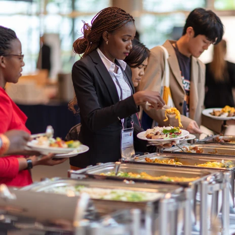 Catering von fairgourmet | Leipzig Convention Bureau Mehrere Personen bedienen sich am Buffet mit Speisen vom fairgourmet Catering – präsentiert vom Leipzig Convention Bureau
