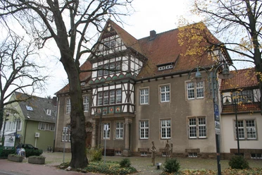 Altes Amtsgericht Petershagen Historisches Gebäude mit Fachwerkdetails, umgeben von Herbstbäumen, im Herzen von Petershagen.