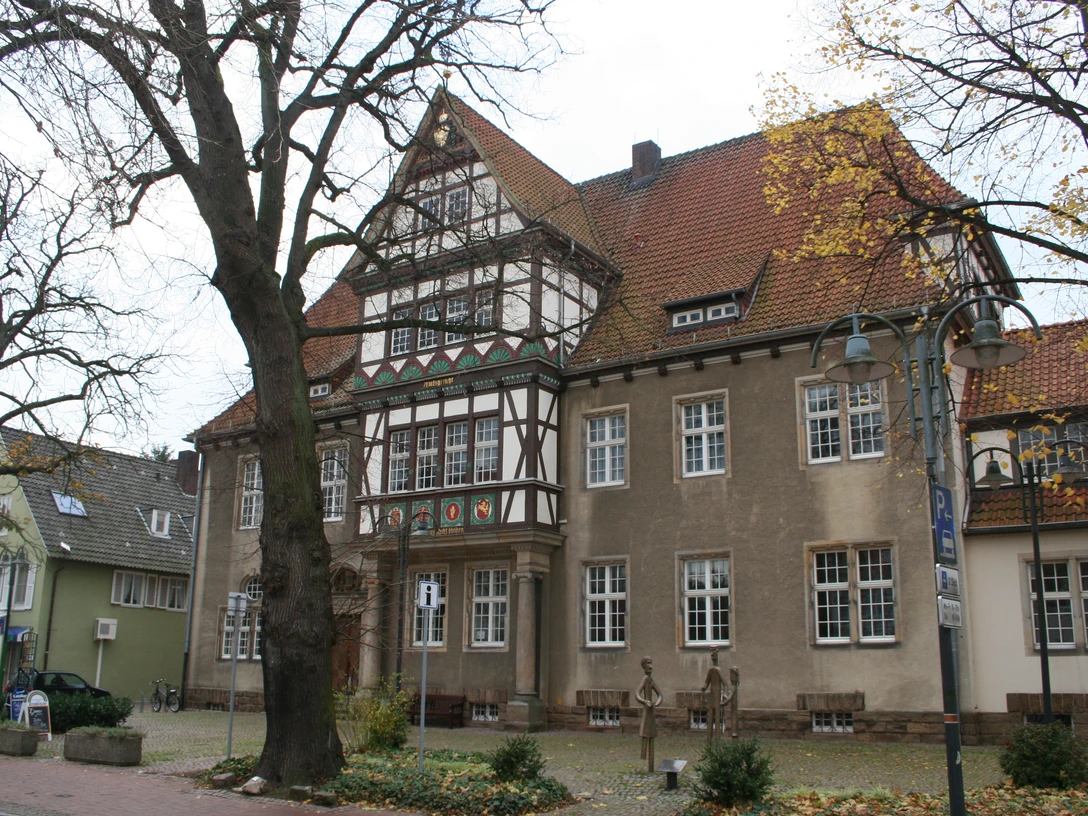 Altes Amtsgericht Petershagen Historisches Gebäude mit Fachwerkdetails, umgeben von Herbstbäumen, im Herzen von Petershagen.