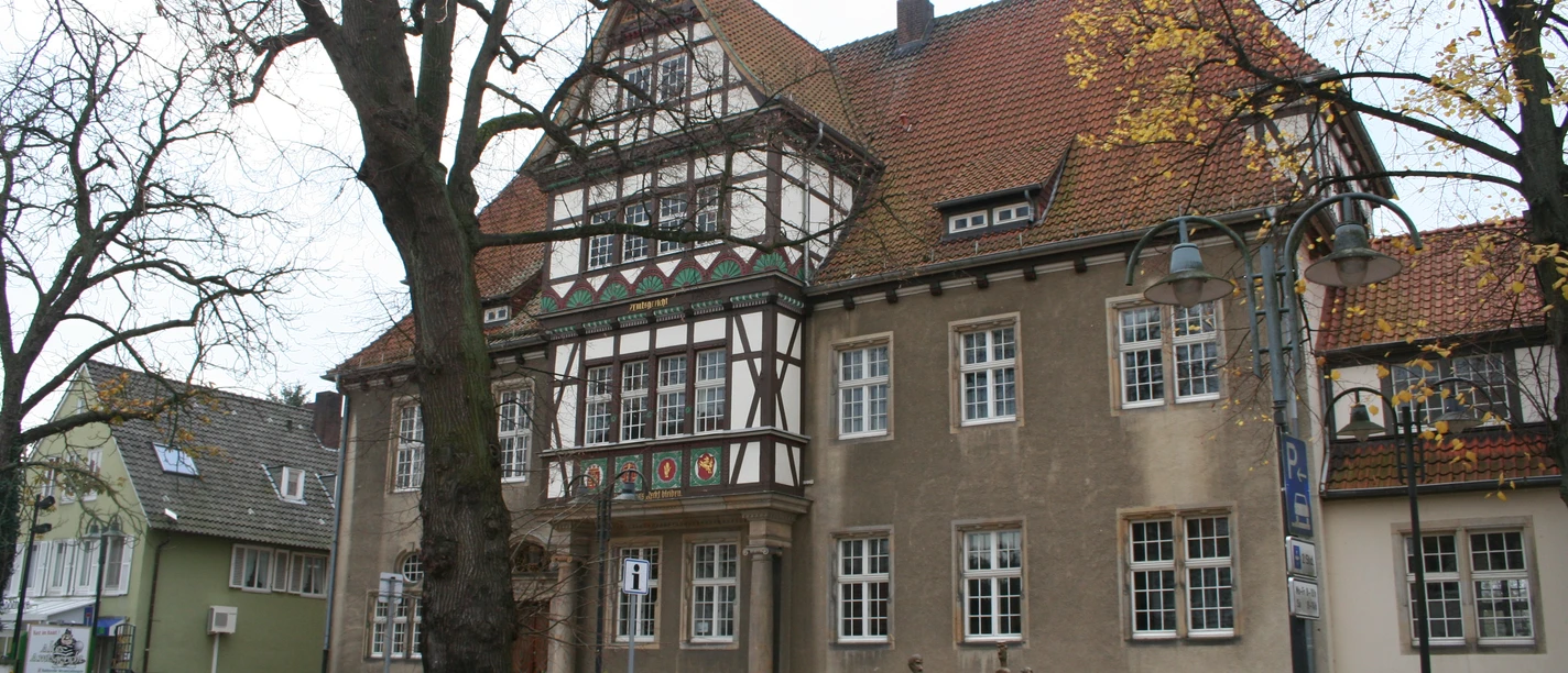 Altes Amtsgericht Petershagen Historisches Gebäude mit Fachwerkdetails, umgeben von Herbstbäumen, im Herzen von Petershagen.