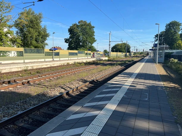 Bahnhof Eystrup Blick auf das Gleis des Bahnhofs Eystrup mit Bahnsteig am sonnigen Tag und Bäumen im Hintergrund.