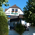 Hausansicht.jpg Hausansicht mit Eingangsbereich und Fenstern mit Blumenschmuck, davor links und rechts grüne Büsche und Bäume, Schriftzug an der weißen Hauswand Landhotel Weserblick Restaurant