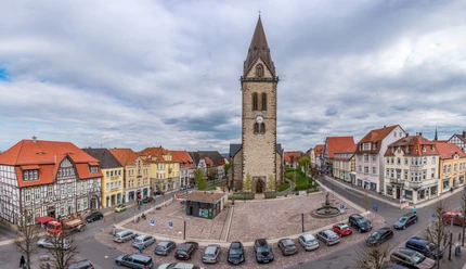 Neustädter Marktplatz (Ruben Emme) Neustädter Marktplatz mit beeindruckender Kirche im Zentrum, umgeben von historischen Fachwerkhäusern und parkenden Autos.