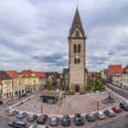 Neustädter Marktplatz (Ruben Emme) Neustädter Marktplatz mit beeindruckender Kirche im Zentrum, umgeben von historischen Fachwerkhäusern und parkenden Autos.