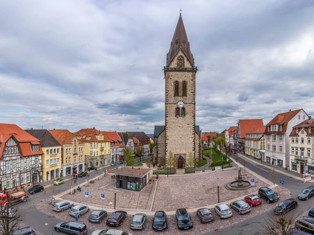 Neustädter Marktplatz (Ruben Emme) Neustädter Marktplatz mit beeindruckender Kirche im Zentrum, umgeben von historischen Fachwerkhäusern und parkenden Autos.