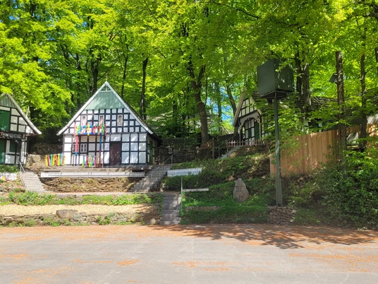 Kahle Wart Freilichtbühne Dreieckige, von Bäumen umgebene Fachwerkhäuser bilden eine malerische Kulisse auf der Freilichtbühne.