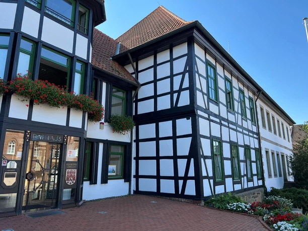 Rathaus Rehburg Historisches Fachwerkgebäude mit Verzierungen und roten Blumen, bekannt als Rathaus von Rehburg.