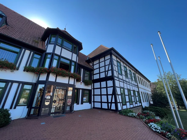 Das Bild zeigt das Fachwerk-Rathaus von Rehburg mit Blumen geschmückten Fenstern und klarer blauer Himmel.