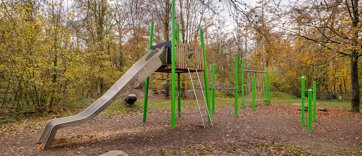 Kinderspielplatz am Wanderparkplatz Hinkesforst in Ratingen Ein moderner Spielplatz mit Rutsche und Klettergerüst, umgeben von herbstlichen Bäumen im Hinkesforst.