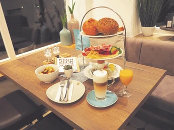 Frühstück in Huberts Café Bös in Ratingen Ein einladender Tisch im Café serviert ein üppiges Frühstück mit Kaffee, Saft und Brötchen.