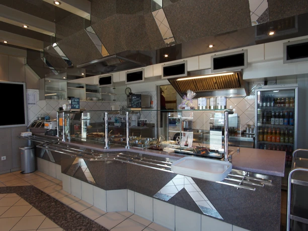 Verkaufsraum2.jpg Helle Verkaufstheke in moderner Gastronomie mit Glasvitrinen und gefliestem Boden.