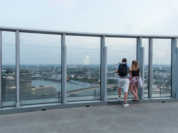 KölnTriangle People on the viewing platform of the Köln Triangle enjoy the view of Cologne under a slightly cloudy sky.