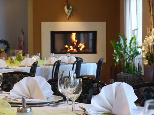 Saal im Haus der Gastlichkeit, Ratingen Ein stilvoll gedeckter Speisesaal mit elegant arrangierten Tischen und einem wärmenden Kamin.
