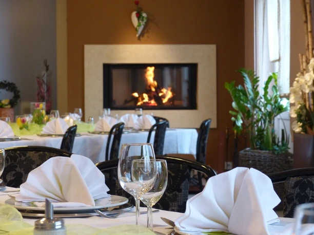 Saal im Haus der Gastlichkeit, Ratingen Ein stilvoll gedeckter Speisesaal mit elegant arrangierten Tischen und einem wärmenden Kamin.