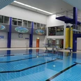 Nizzabad bei Velbert-Langenberg Ein modernes Hallenbad mit klar strukturiertem Becken, Leitern, Sprungturm und farbenfrohen Wandbildern.
