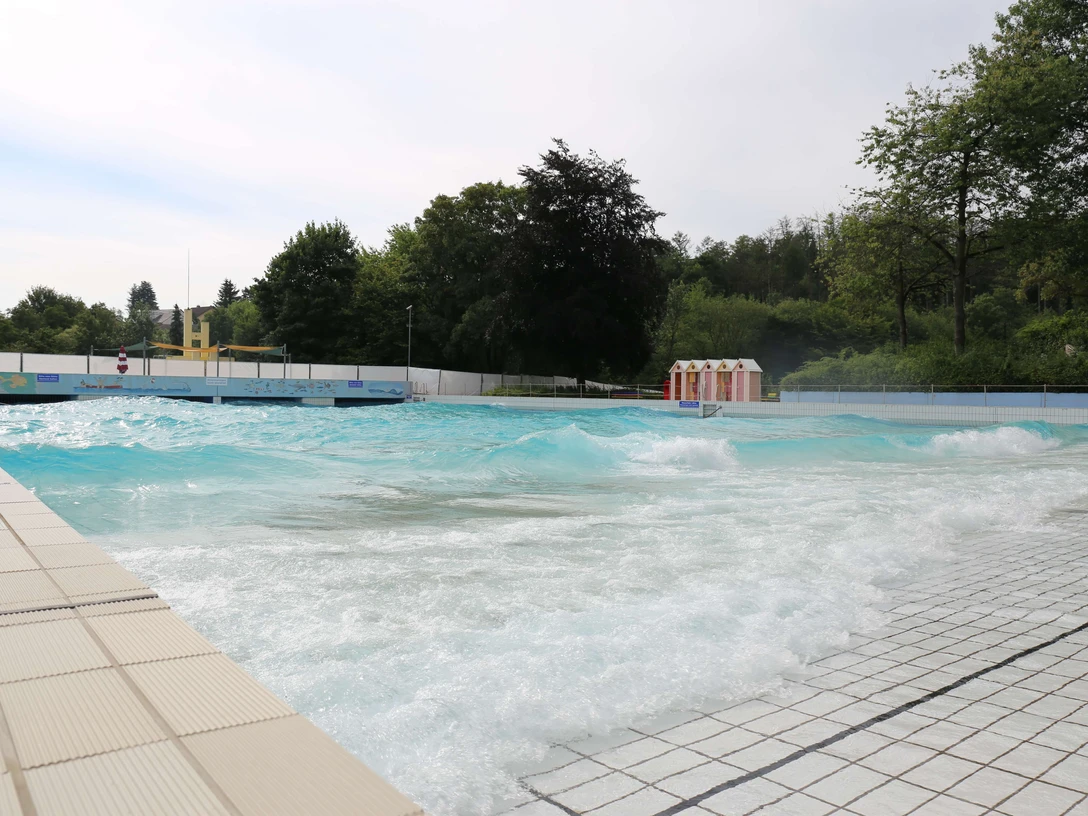 Panoramabad in Velbert Ein weitläufiges Freibad in Velbert mit türkisfarbenem Wasser und umliegendem Grün.
