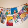 Malzauber-Malkurse Kreative Kinderzeichnungen an einer Schnur aufgehängt, präsentieren bunte Tiere und fantasievolle Szenen.