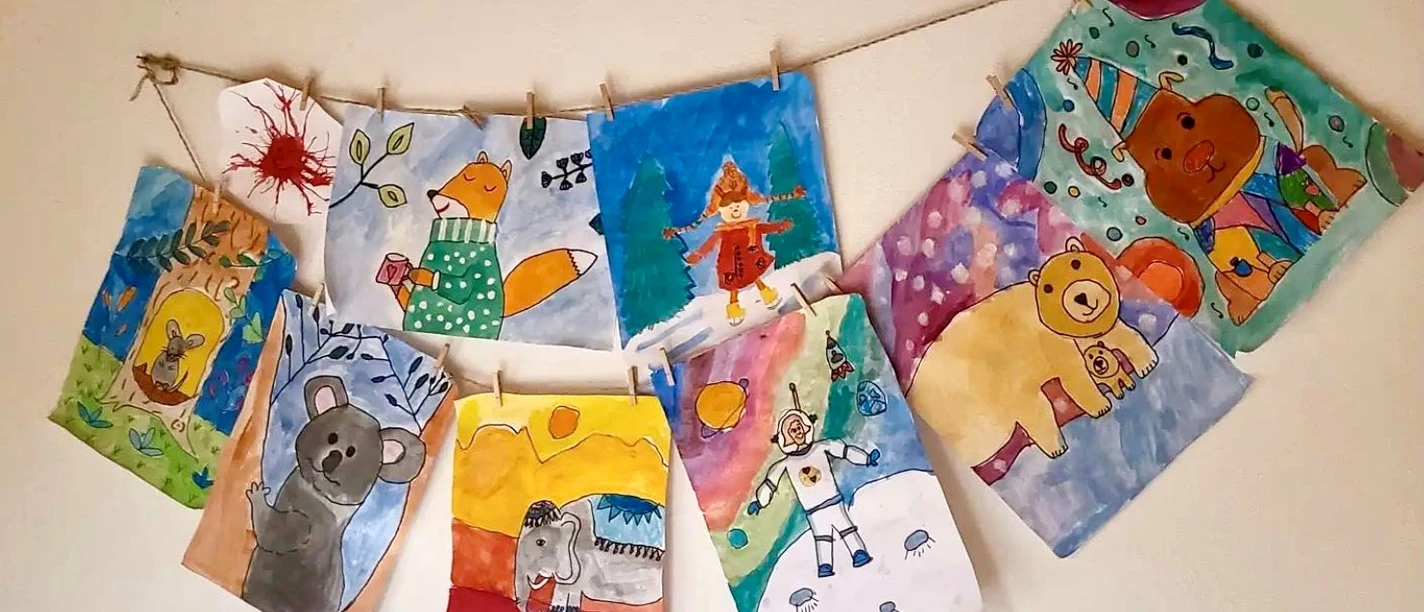 Malzauber-Malkurse Kreative Kinderzeichnungen an einer Schnur aufgehängt, präsentieren bunte Tiere und fantasievolle Szenen.