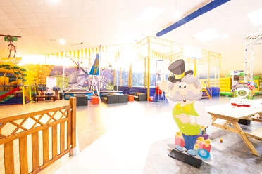 Funky Town in Ratingen Ein Indoor-Spielplatz mit bunten Klettergerüsten und einer lebensgroßen Figur eines älteren Mannes.