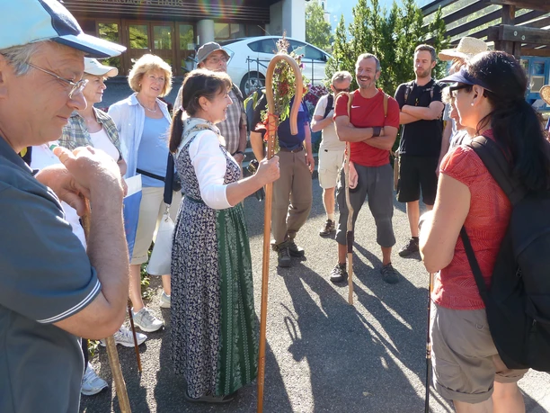 Pilgerwanderung Gruppe Gruppe von Pilgern mit Stöcken auf einer Wanderung, eine Frau teilt Informationen.