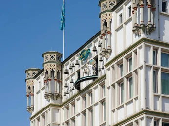 4711 Dufthaus Die Fassade des 4711-Duftmuseums mit dem Glockenspiel vor blauem Himmel.The façade of the 4711 fragrance museum with the carillon against a blue sky.