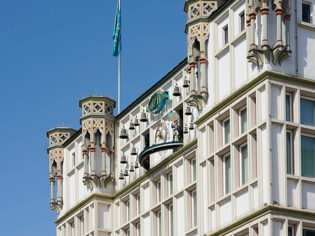 4711 Dufthaus Die Fassade des 4711-Duftmuseums mit dem Glockenspiel vor blauem Himmel.