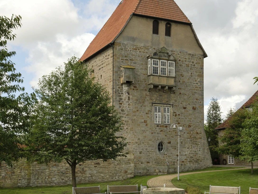 Schloss Sachsenhagen Schloss Sachsenhagen aus Bruchsteinen mit Erkerturm, umgeben von grünen Bäumen und gepflegter Anlage.