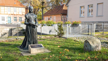 Schloss Fallersleben Bronzestatue einer Herzogin im Garten von Schloss Fallersleben vor Fachwerk- und Putzbauten.