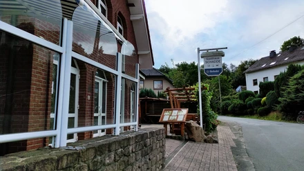 Traditionelles Gasthaus in Backsteinbauweise mit überdachtem Eingang und urigen Holzelementen.