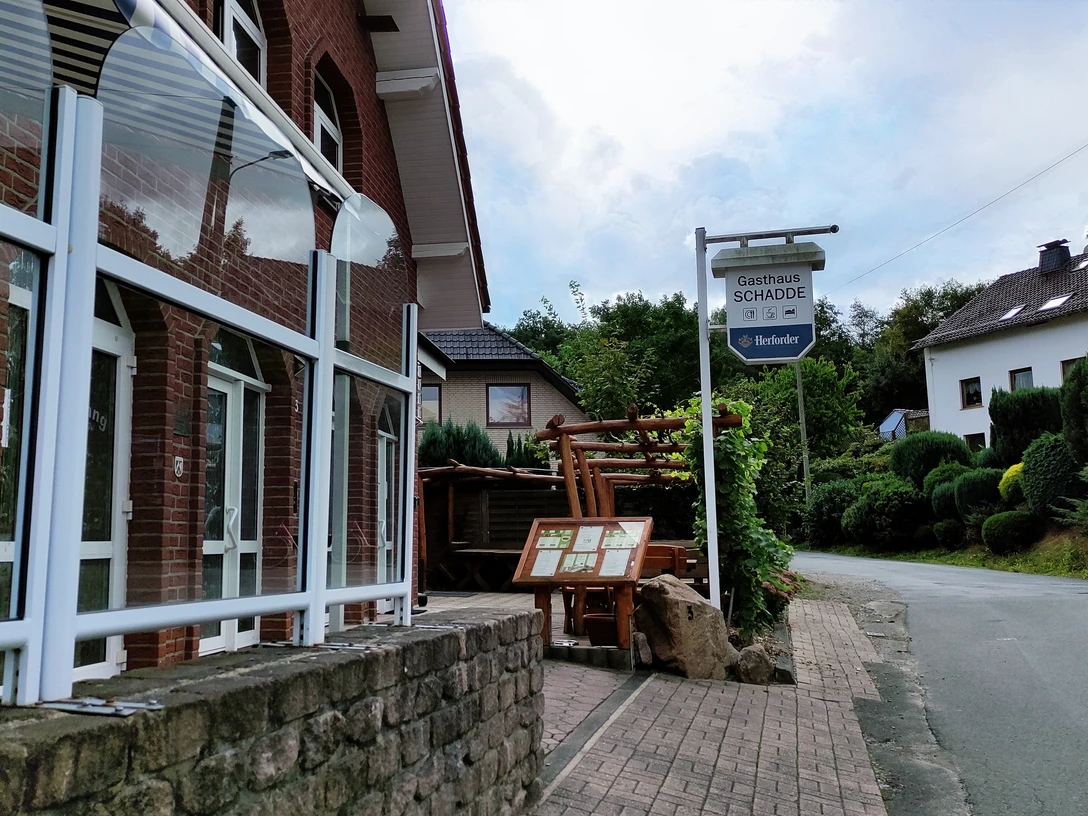 Traditionelles Gasthaus in Backsteinbauweise mit überdachtem Eingang und urigen Holzelementen.