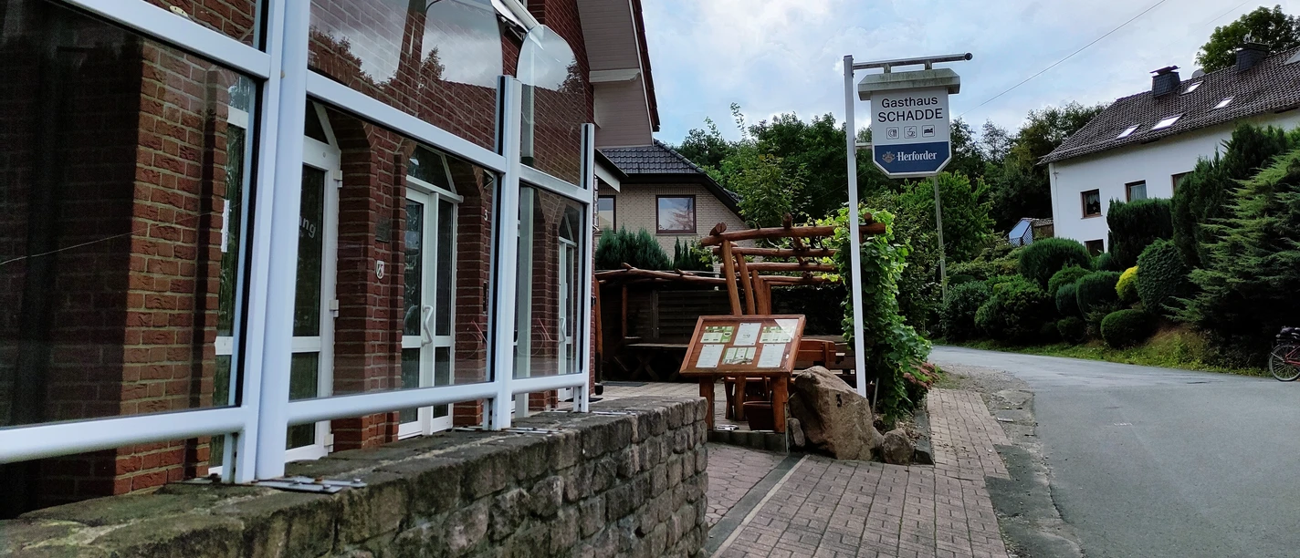 Traditionelles Gasthaus in Backsteinbauweise mit überdachtem Eingang und urigen Holzelementen.
