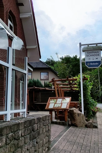 Traditionelles Gasthaus in Backsteinbauweise mit überdachtem Eingang und urigen Holzelementen.