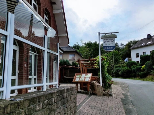 Traditionelles Gasthaus in Backsteinbauweise mit überdachtem Eingang und urigen Holzelementen.