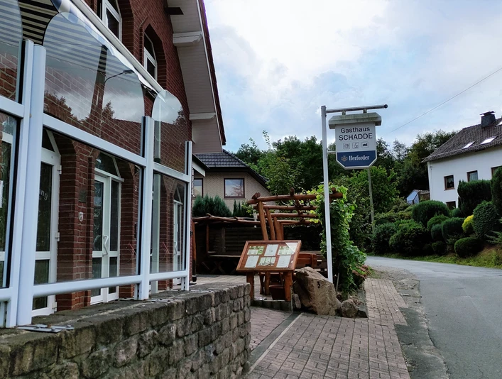 Traditionelles Gasthaus in Backsteinbauweise mit überdachtem Eingang und urigen Holzelementen.