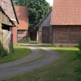 Historisches Viertel in Schlüsselburg mit rustikalen Scheunen aus Backstein und Holz entlang eines Weges.