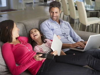 Family,On,Sofa,With,Laptop,And,Digital,Tablet,Watching,Tv Family,On,Sofa,With,Laptop,And,Digital,Tablet,Watching,Tv