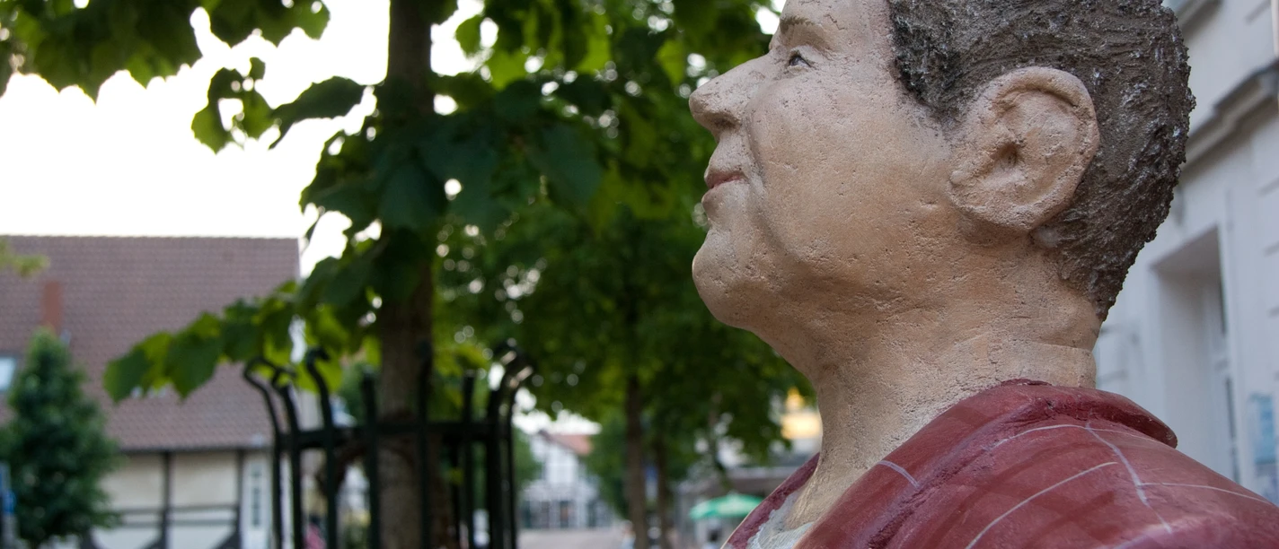 Lechnerfigur "Herr Meier" Lechnerfigur "Herr Meier" unter einem Baum, mit Fachwerkhäusern im Hintergrund.